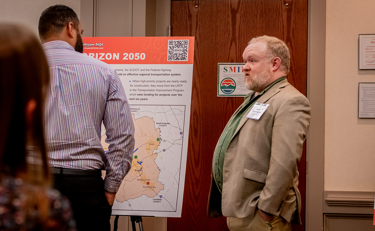 Project team member, Keith Brockington, speaking with a meeting attendee.